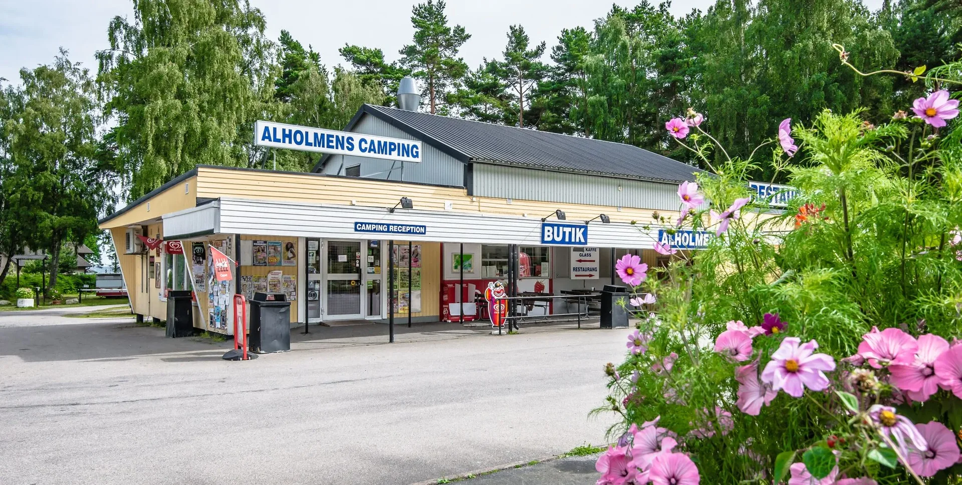 Receptionsbyggnad med butik och blommor i förgrunden