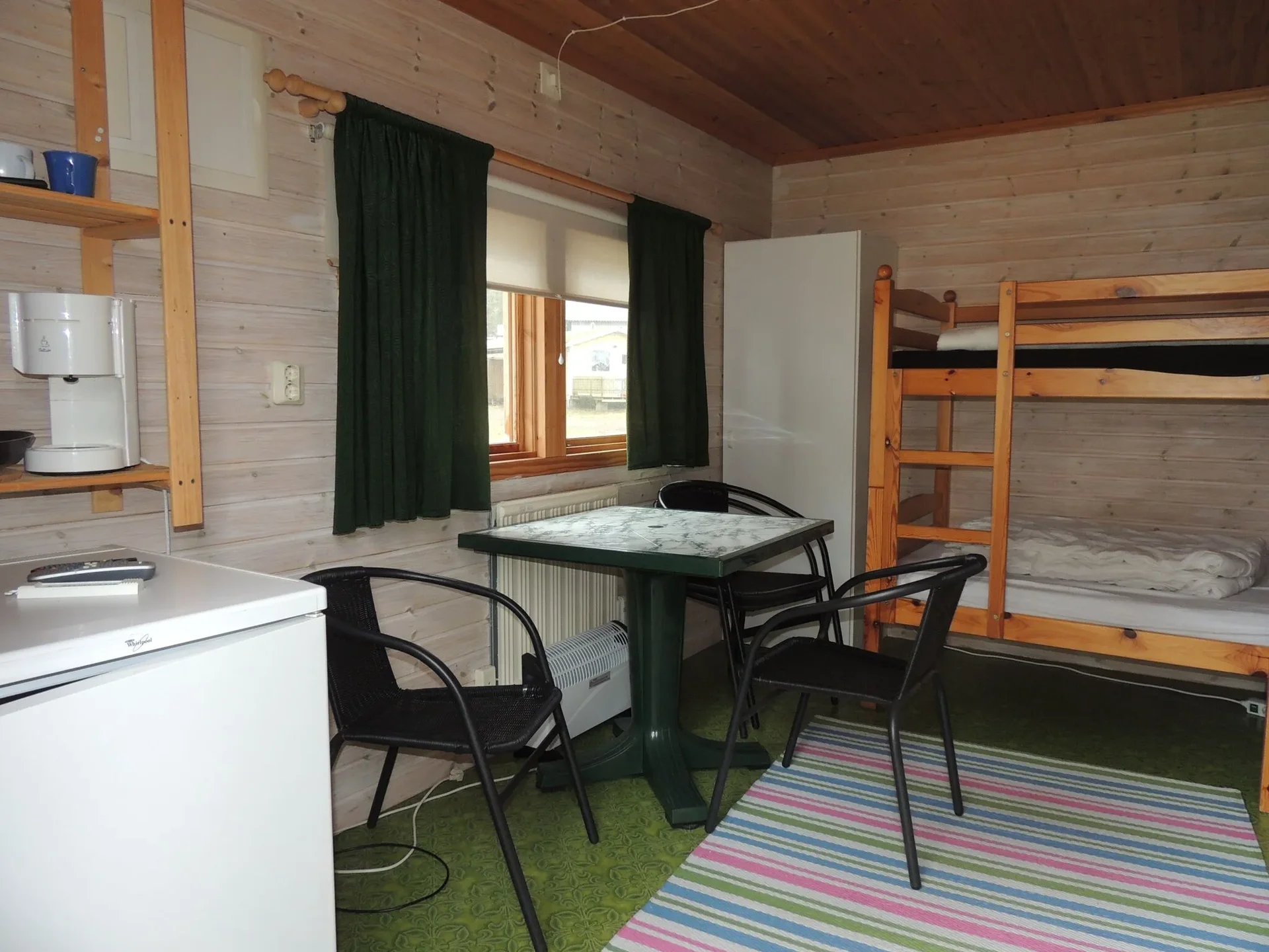 Stuginteriör med våningssäng, matbord och pentry