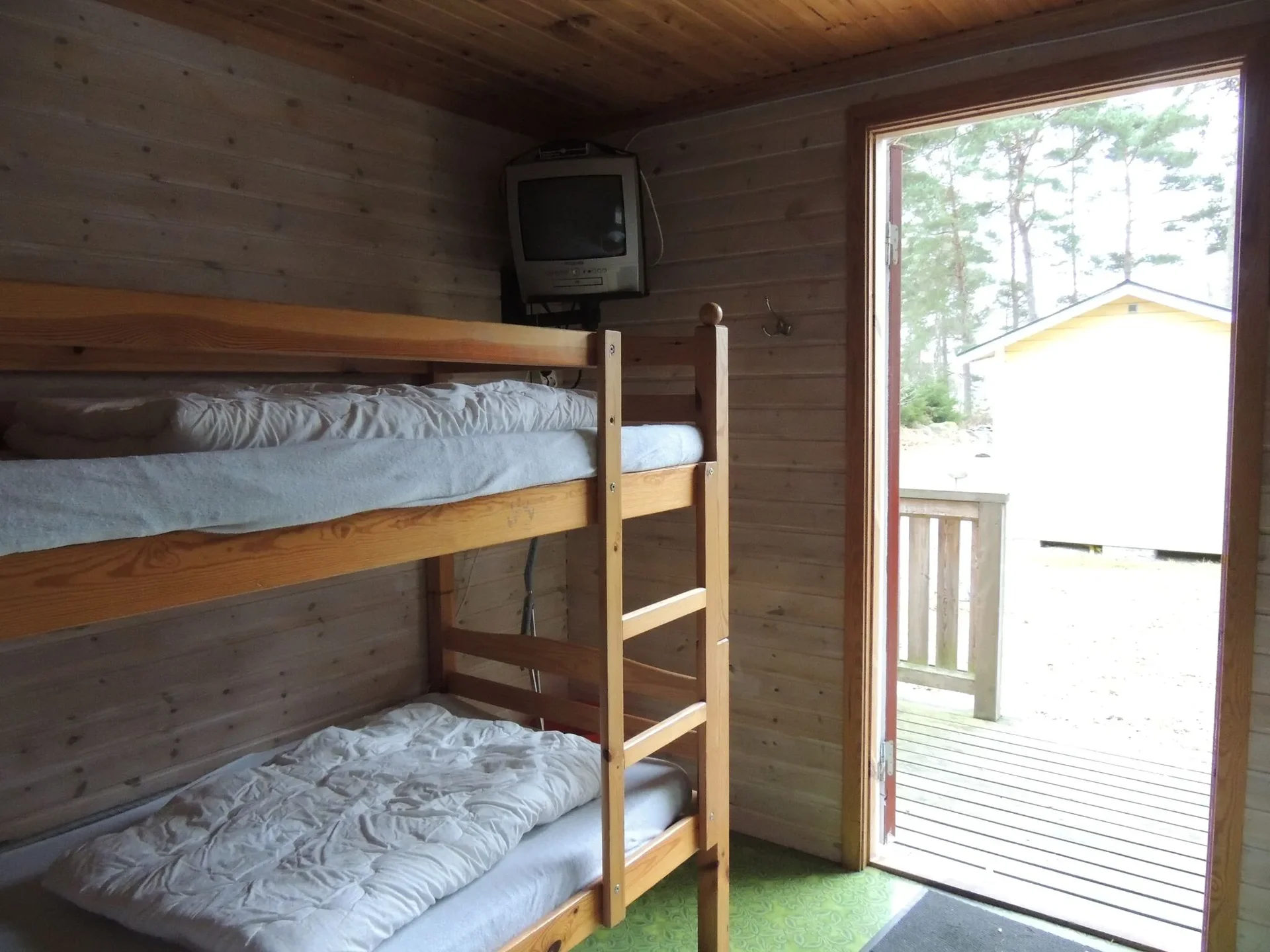 Sovrum i stuga med våningssäng och öppen altandörr