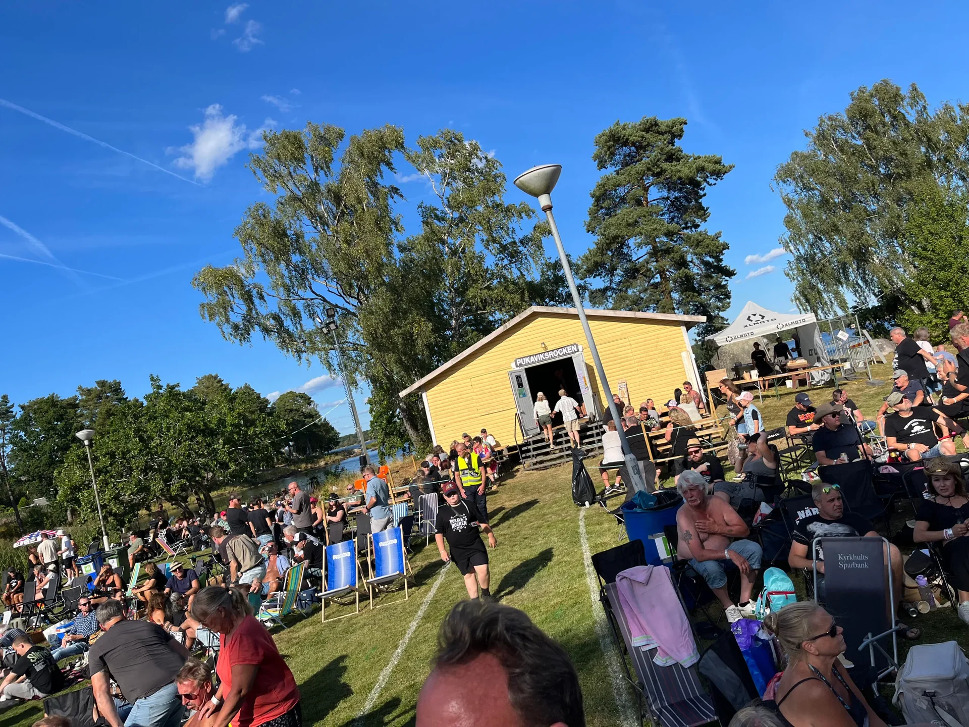 Folkträngsel vid gul scenbyggnad på festival
