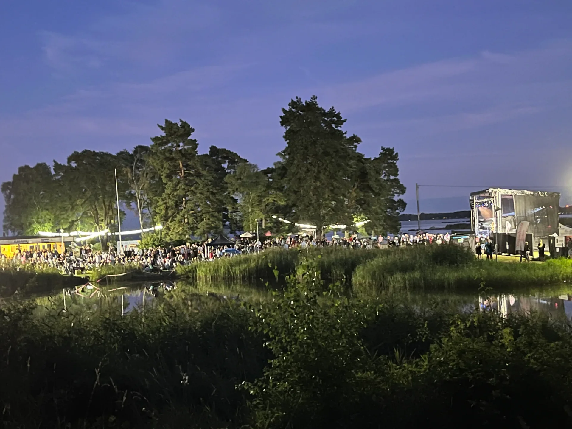 Festivalområde vid vattnet i skymningsljus