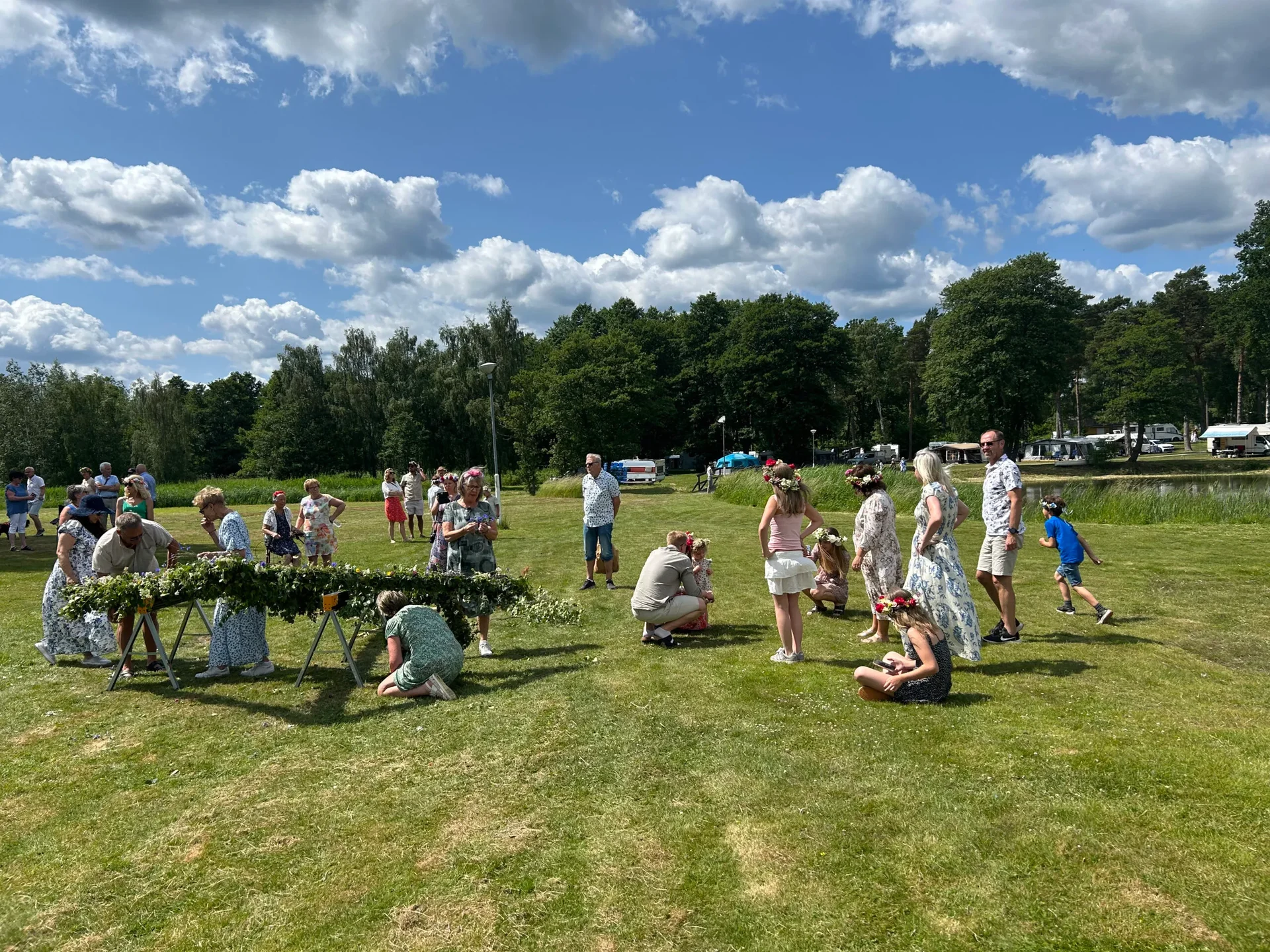 Barn och vuxna leker på gräset under midsommarfirande