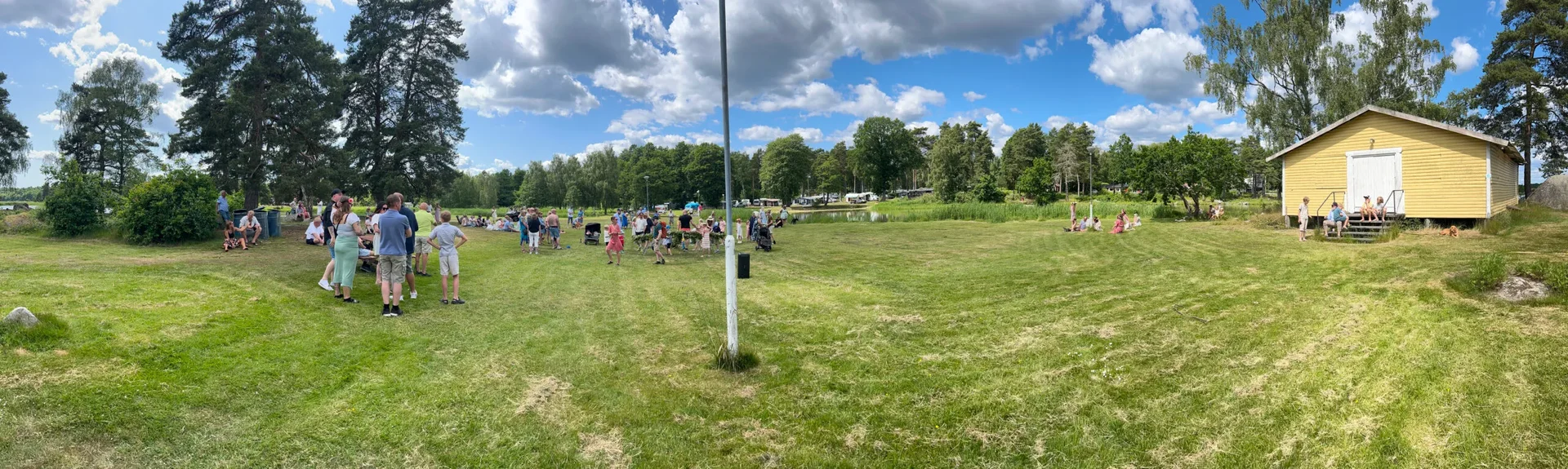 Händer som binder midsommarkrans av blommor i gräset