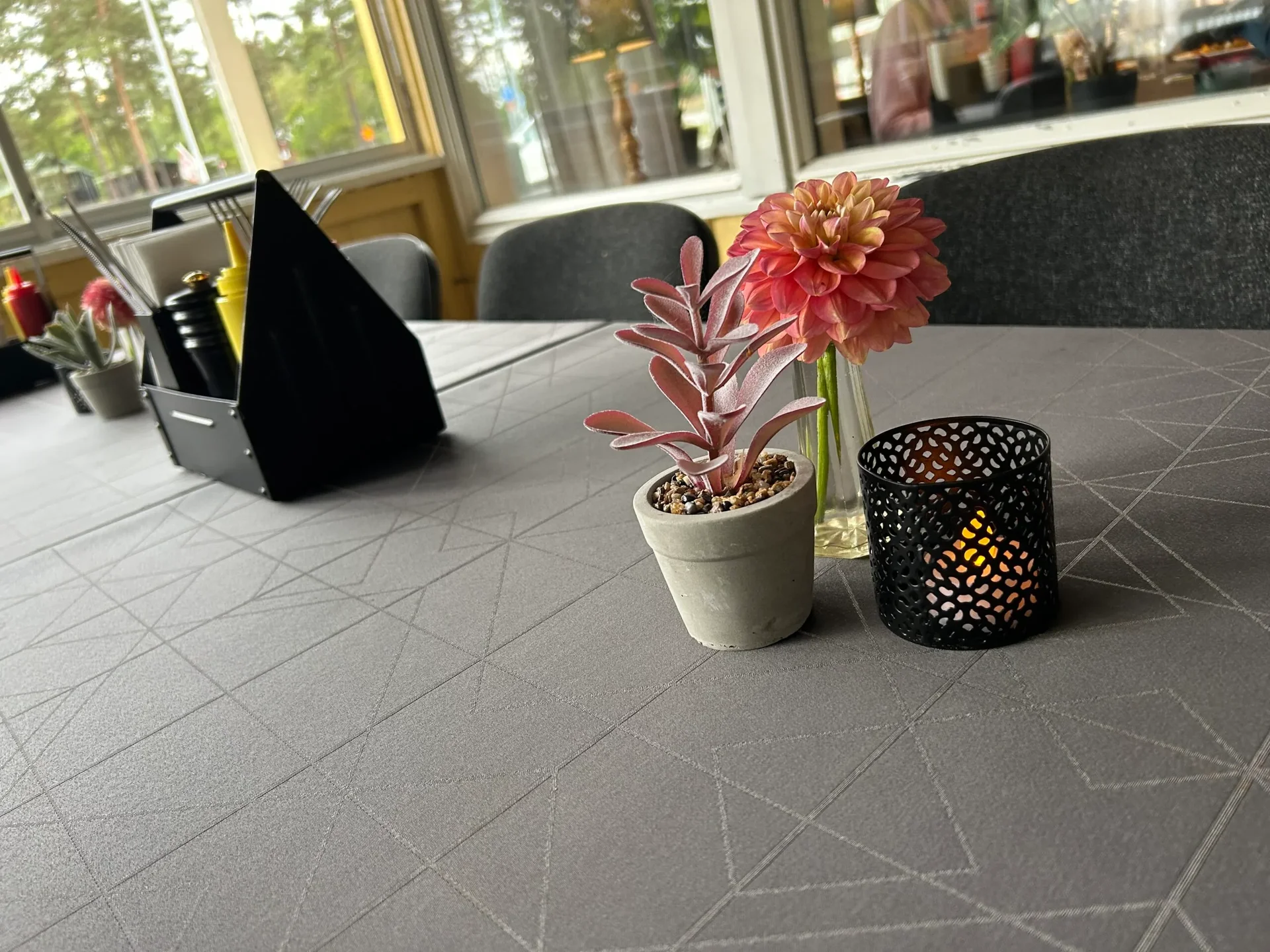 Dukat bord med dahlia, krukväxt och värmeljus i ljus matsal